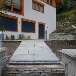 Réalisation de 2019 à 2020 - Habillage en pierres de parement et terrasse en luzerne, et escalier en granit sur chalet de prestige